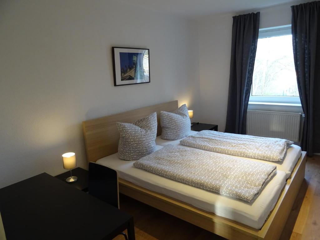 ein Schlafzimmer mit einem Bett mit zwei Kissen und einem Fenster in der Unterkunft BS Living Apartment 4 in Braunschweig