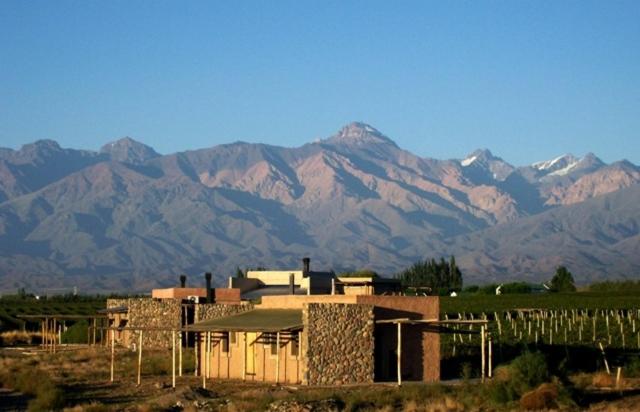 uma casa em frente a uma montanha com montanhas em Tupungato Divino em Tupungato
