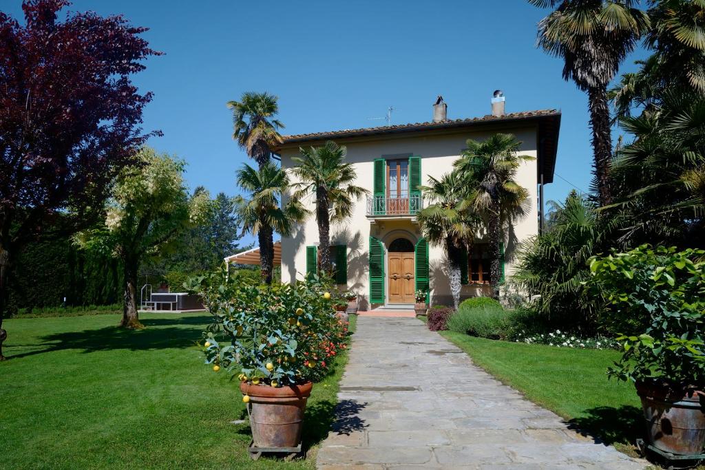 a house with palm trees and a pathway at Villa Le Facezie B&B in Terranuova Bracciolini