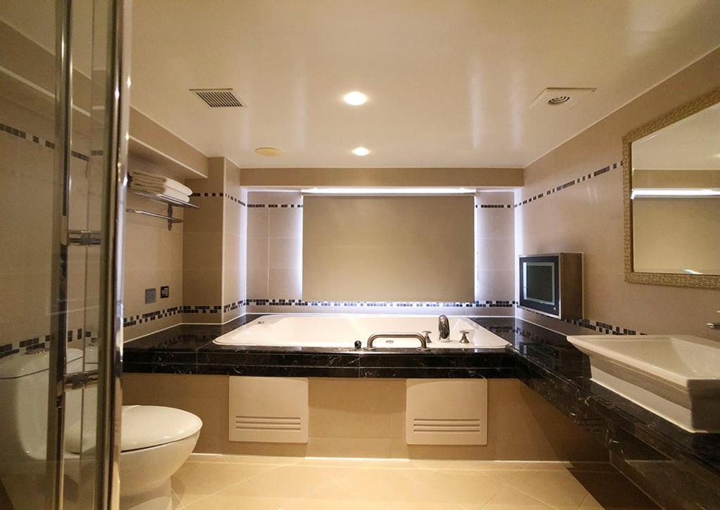 a bathroom with a tub and a toilet and a sink at Shihzuwan Hotel – Kaohsiung Station in Kaohsiung