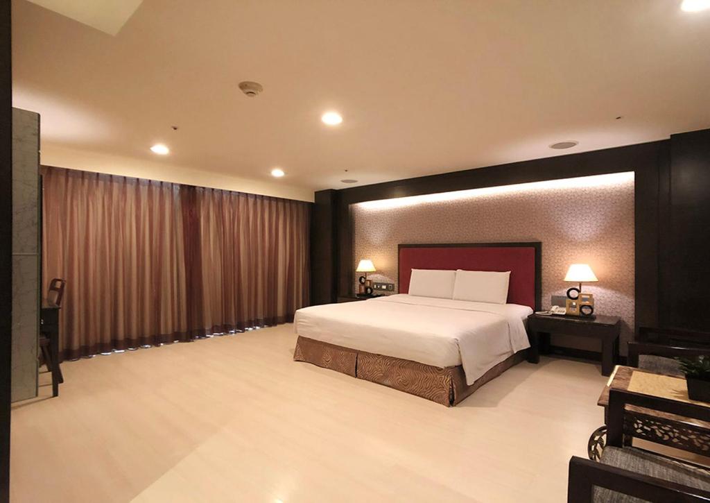 a bedroom with a large bed in a room at Shihzuwan Hotel – Kaohsiung Station in Kaohsiung