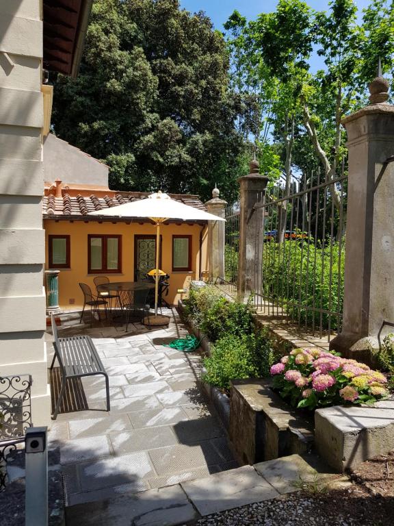 patio ze stołem, parasolem i kwiatami w obiekcie Machiavelli Apartment by Firenze Prestige we Florencji