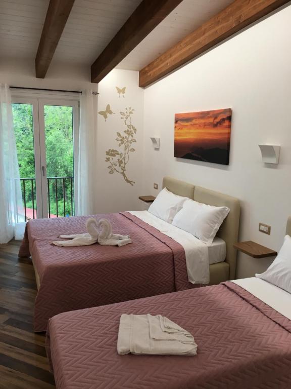 pokój hotelowy z 2 łóżkami i ręcznikami w obiekcie Il covo degli Dei w mieście Agerola