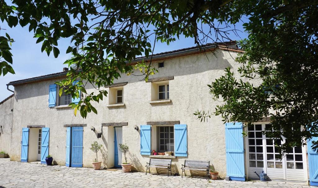 a white building with blue shutters on it at La Bergerie De Valerie in Arthès