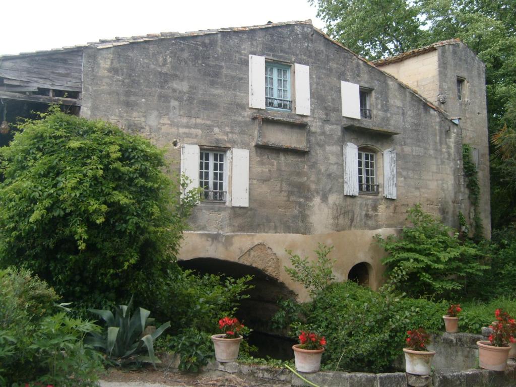 ユゼスにあるMoulin du Pont d'Alzonの窓と植物のある古い石造りの建物