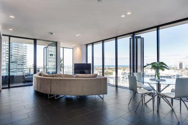 ein Wohnzimmer mit einem großen Sofa und einem Tisch in der Unterkunft Apartmentsouthbank in Melbourne