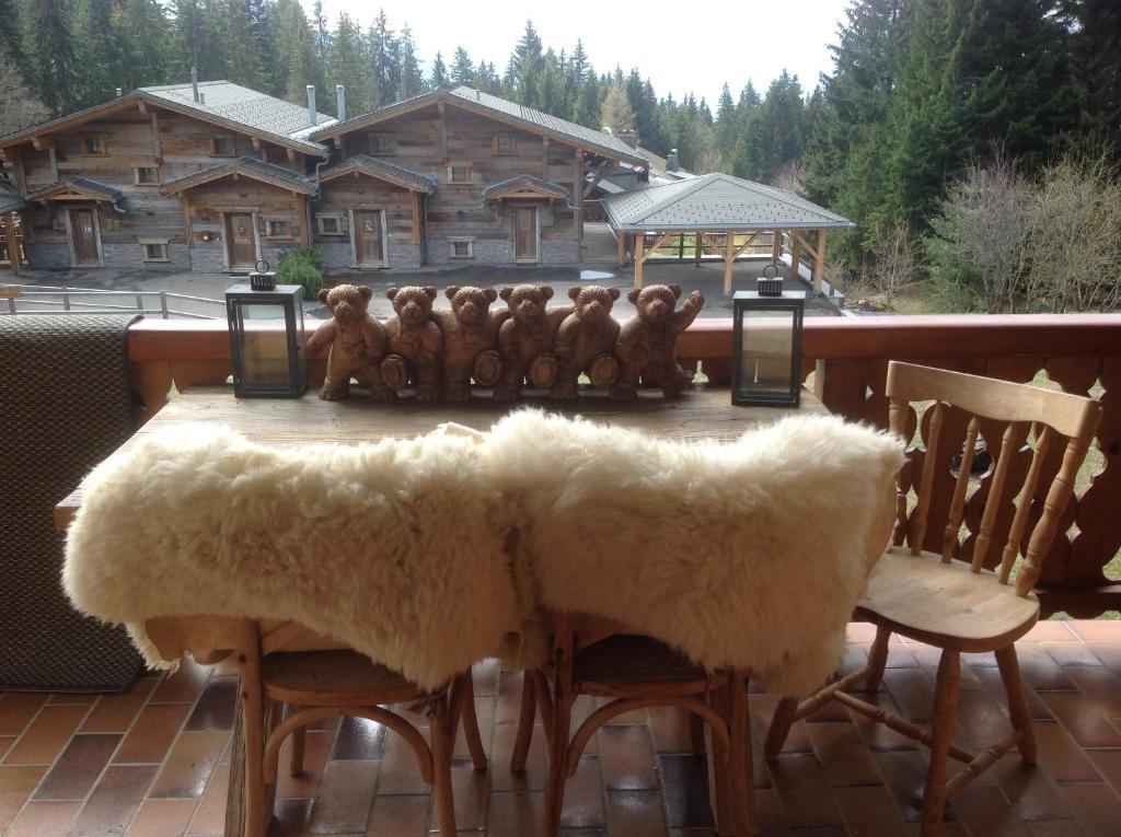 a table with stuffed teddy bears sitting on a deck at Petit Ours in Villars-sur-Ollon