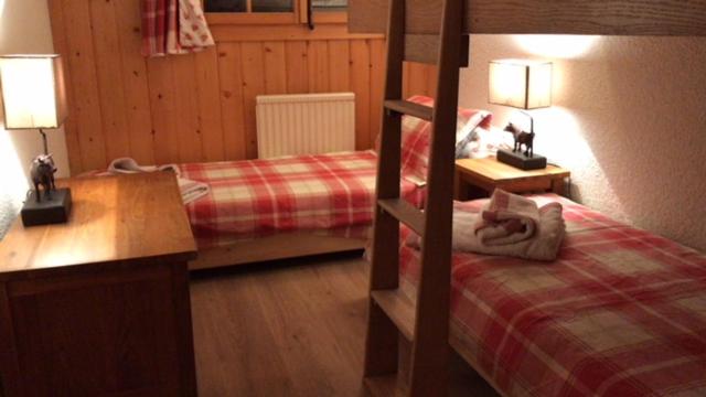 a bedroom with two beds and a desk and two lamps at Petit Ours in Villars-sur-Ollon