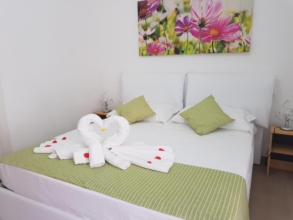 ein Bett mit zwei herzförmigen Handtüchern in der Unterkunft B&B Fior di Mare in Porto Cesareo