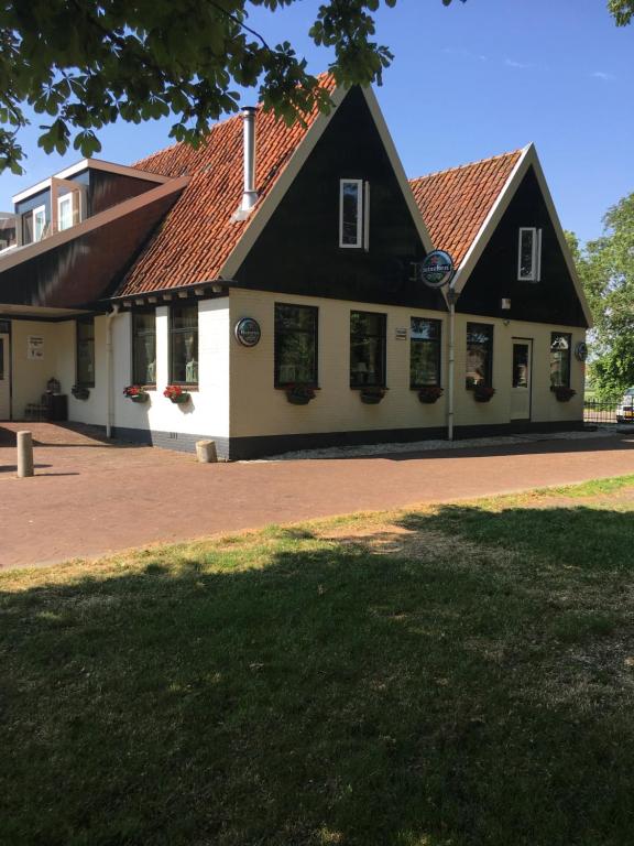 een huis met een zwart-wit gebouw bij 't Wapen van Middelie in Middelie