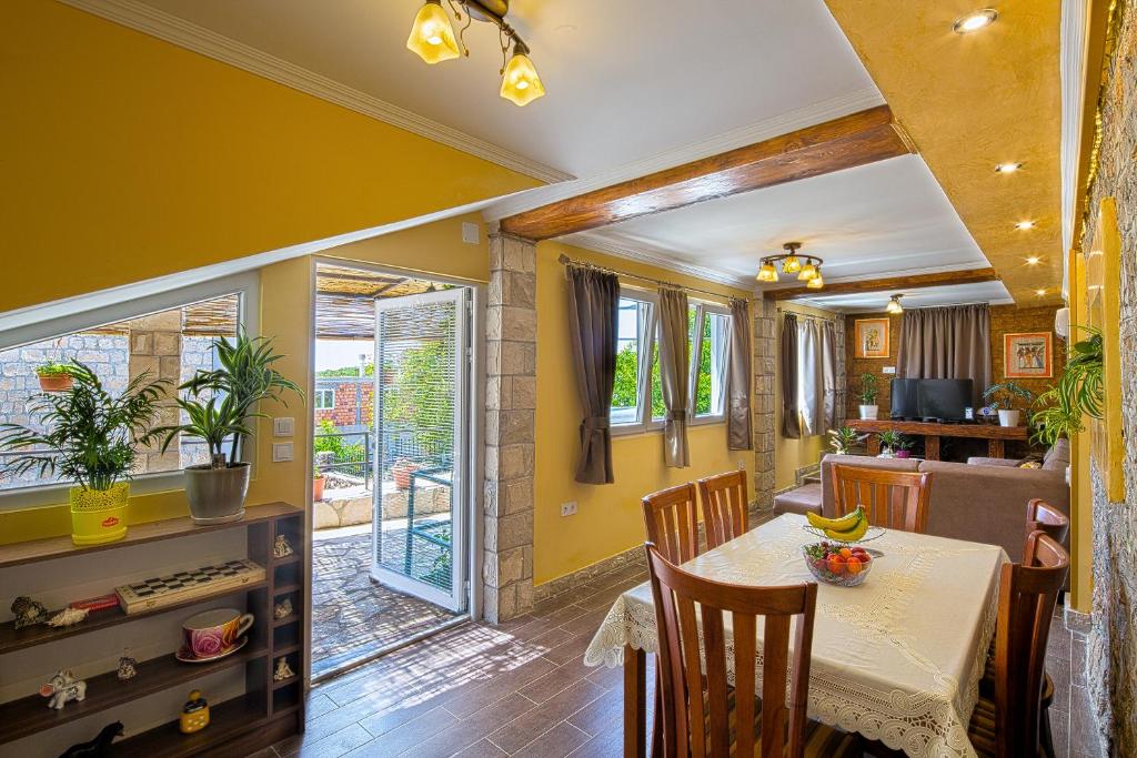 une salle à manger avec des murs jaunes, une table et des chaises dans l'établissement Apartman Kunjić, à Krimovice