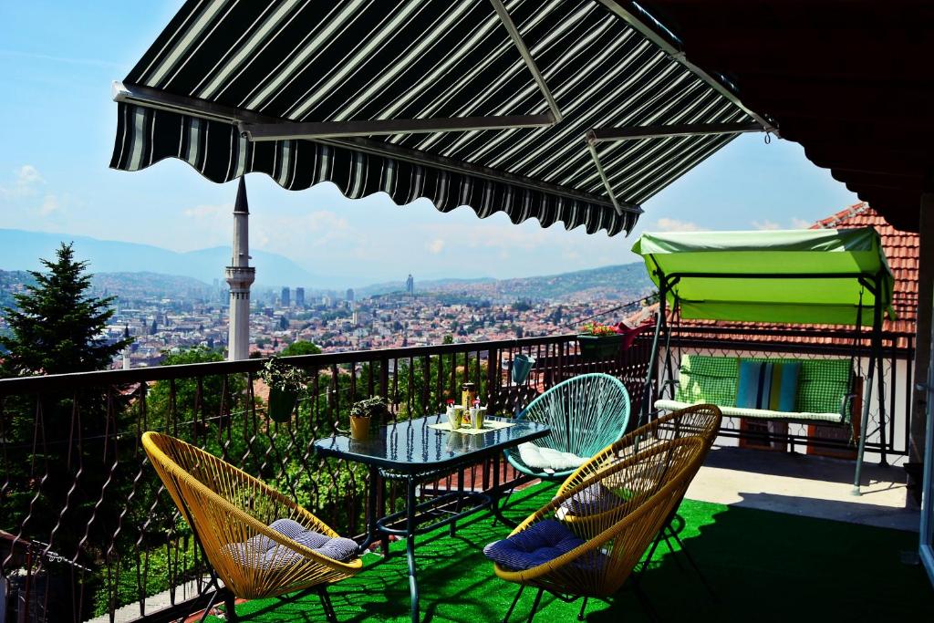 a patio with a table and chairs and an umbrella at Romantic in Sarajevo