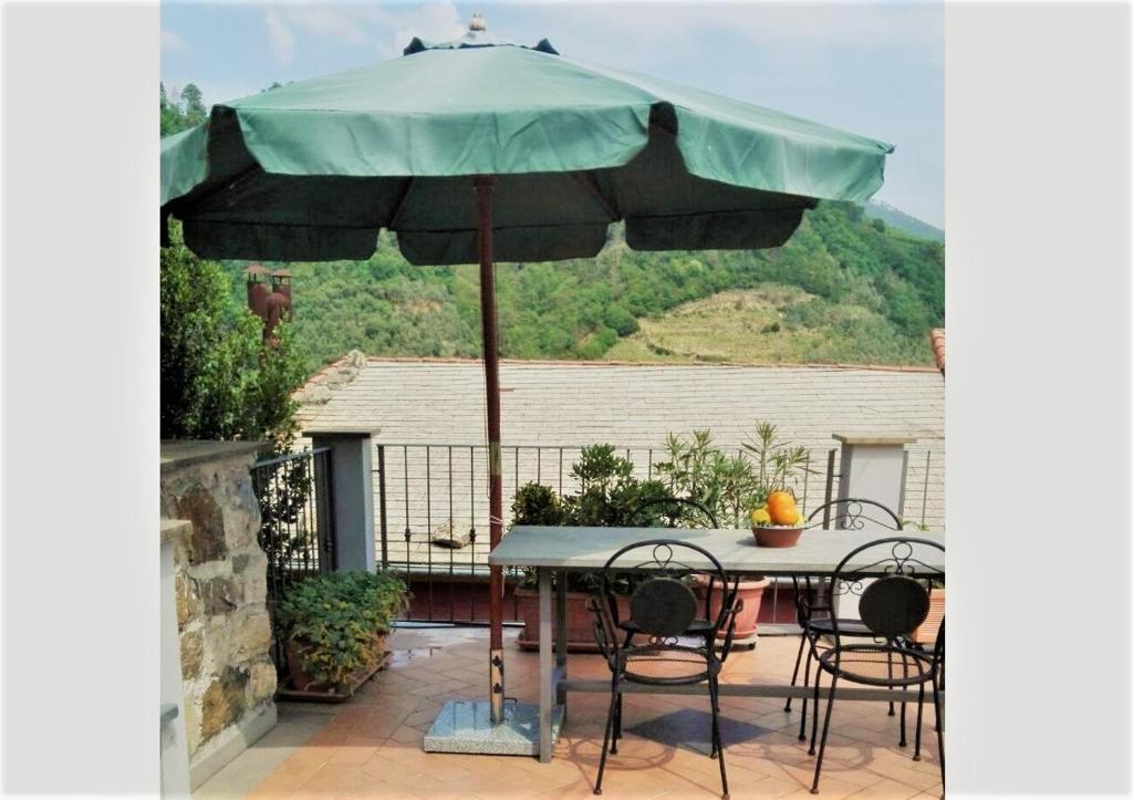 un tavolo e sedie sotto un ombrellone su un patio di Charme e Relax a Levanto