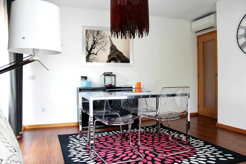 a dining room with a glass table and two chairs at Feel Coimbra Apartments in Coimbra