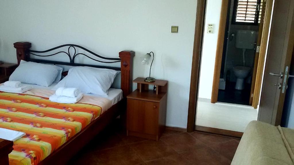 een slaapkamer met een bed en een lamp op een tafel bij Apartmani Mirista in Herceg-Novi