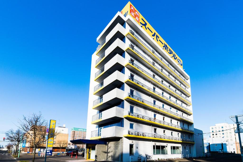 un edificio alto con un cartel en el costado en Super Hotel Kushiro Natural Hot Spring, en Kushiro