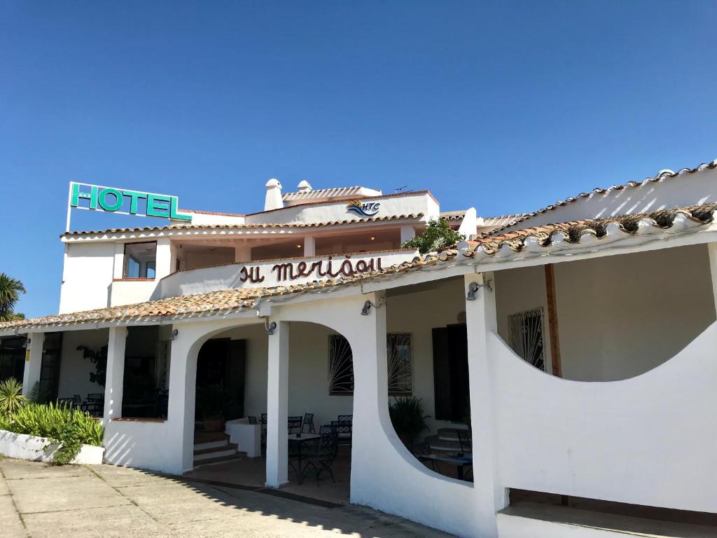 un edificio blanco con un cartel encima en Hotel Su Meriagu, en Capitana