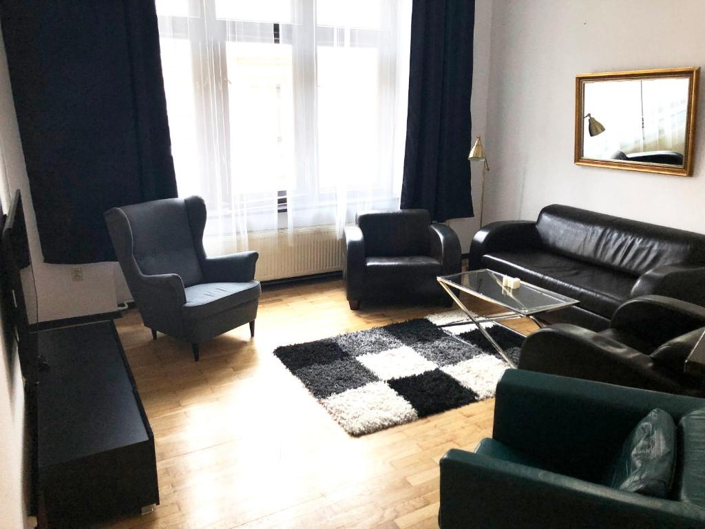 salon z czarną kanapą i krzesłami w obiekcie GLAMOUR Apartment Florianska 32 w Krakowie