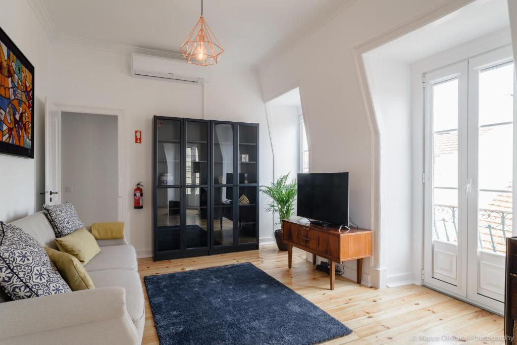 a living room with a couch and a tv at Estefânia RoofTop Apartment - Lisbon Center (NEW) in Lisbon