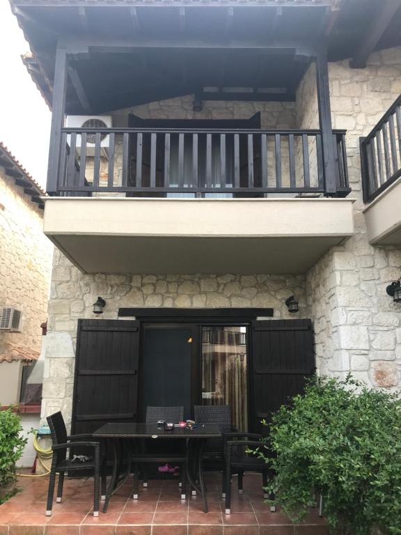 eine Terrasse mit einem Tisch und einem Balkon in der Unterkunft Afytos house in Afytos