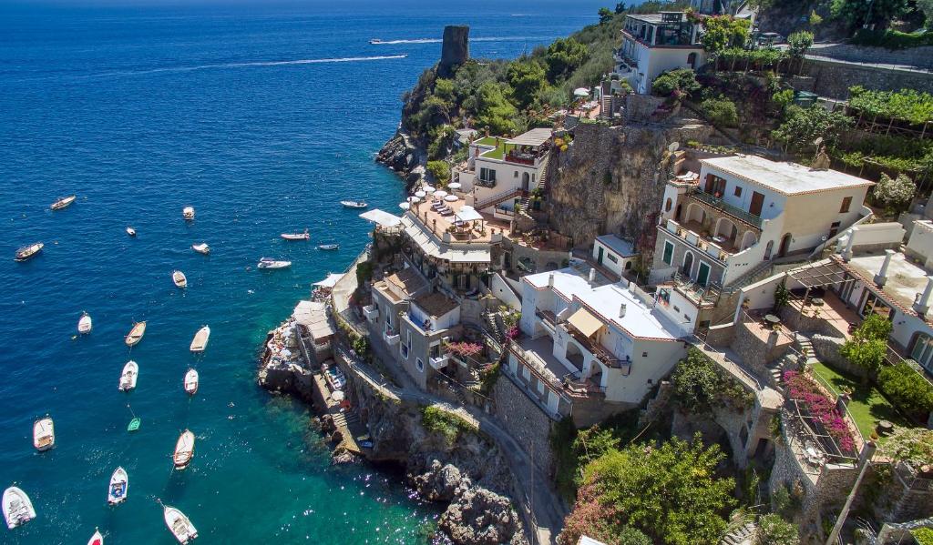an aerial view of a village on a cliff with boats in the water at Hotel Onda Verde in Praiano