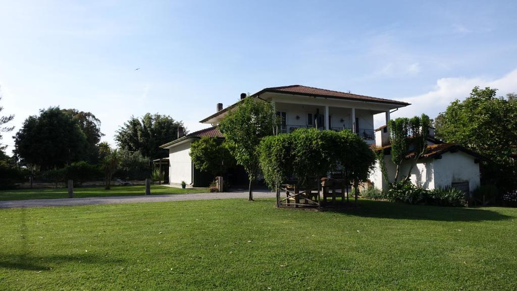 Casa Vacanze Feudi 1165 في Borgo Vodice: منزل أمامه حديقة خضراء