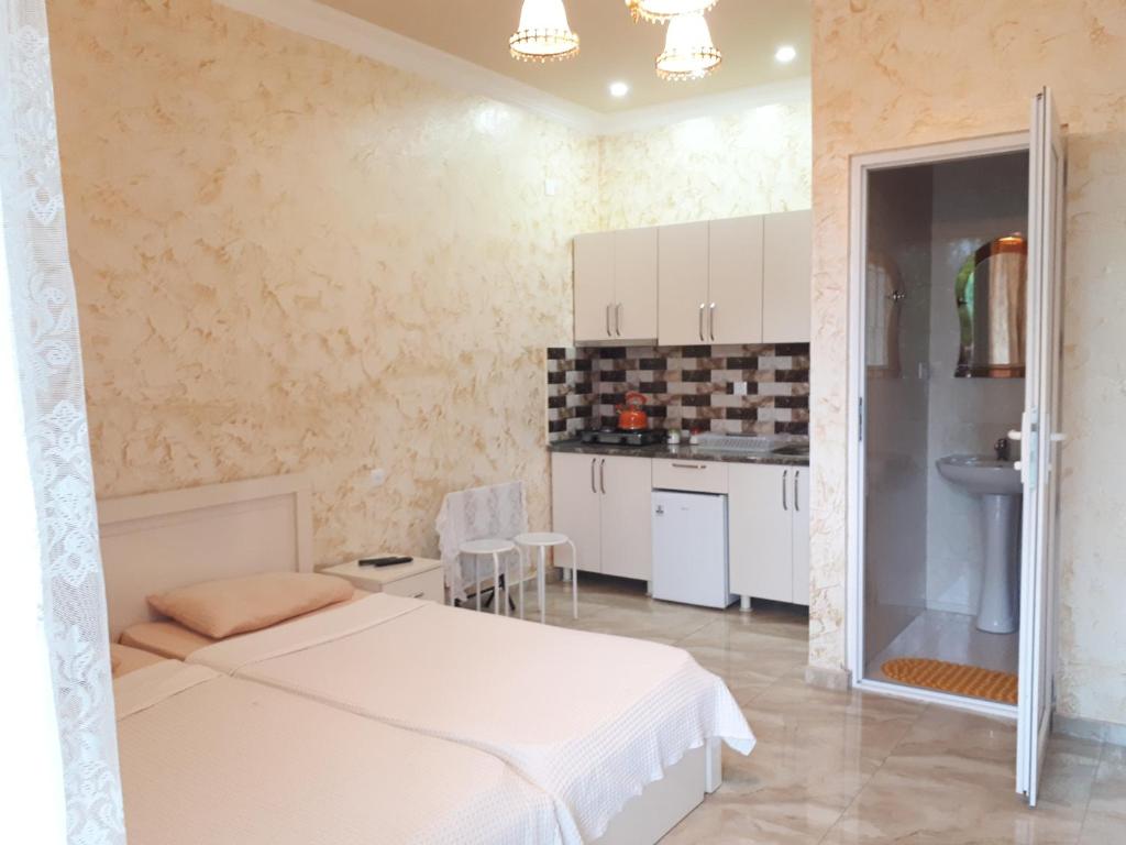 a bedroom with a white bed and a kitchen at Apartment MaxinJauri in Makhinjauri