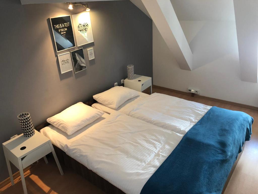 Un dormitorio con una gran cama blanca con una manta azul. en Apartamenty Szabla Bydgoszcz 1, en Bydgoszcz