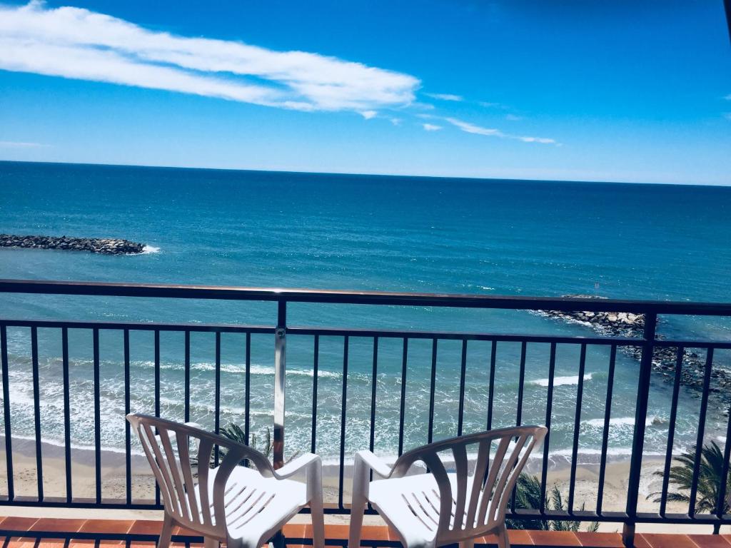 two chairs sitting on a balcony looking at the ocean at Valparaiso Seafront in Cunit