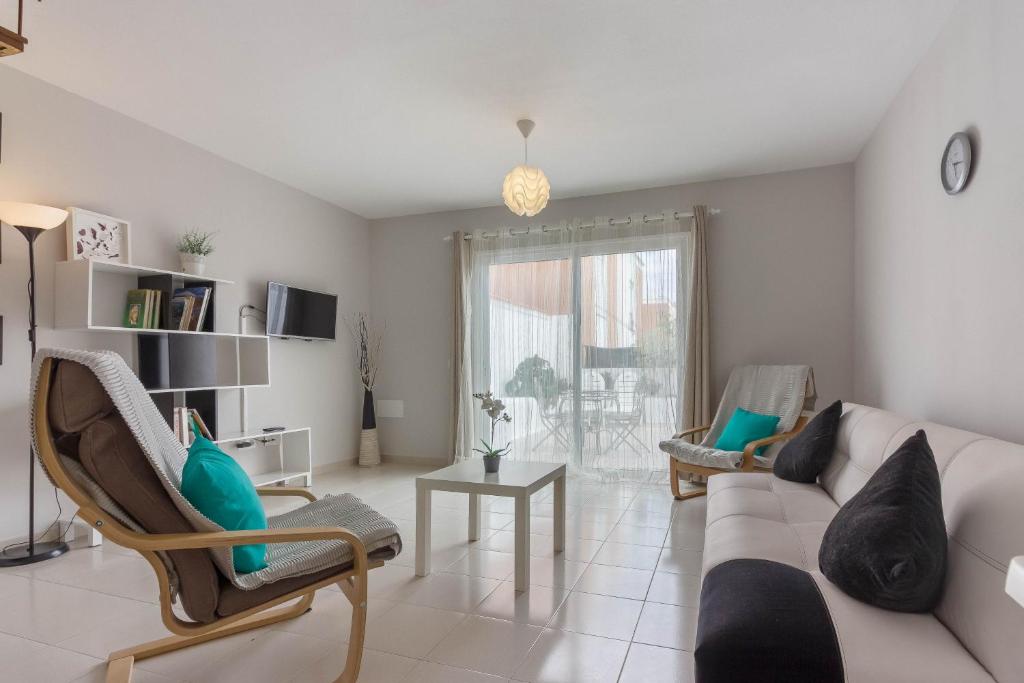 a living room with a couch and chairs and a window at Beautiful 2-bed townhouse near La Tejita beach/El Medano! in La Tejita