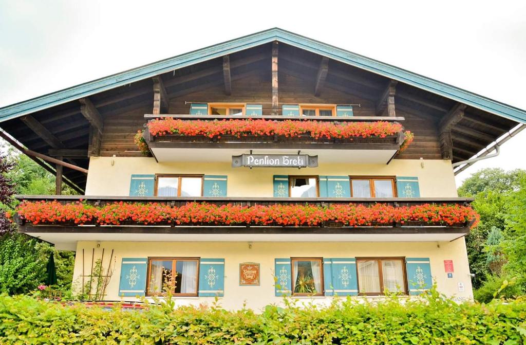 ein Gebäude mit Blumen auf der Seite in der Unterkunft Pension Greti in Schönau am Königssee