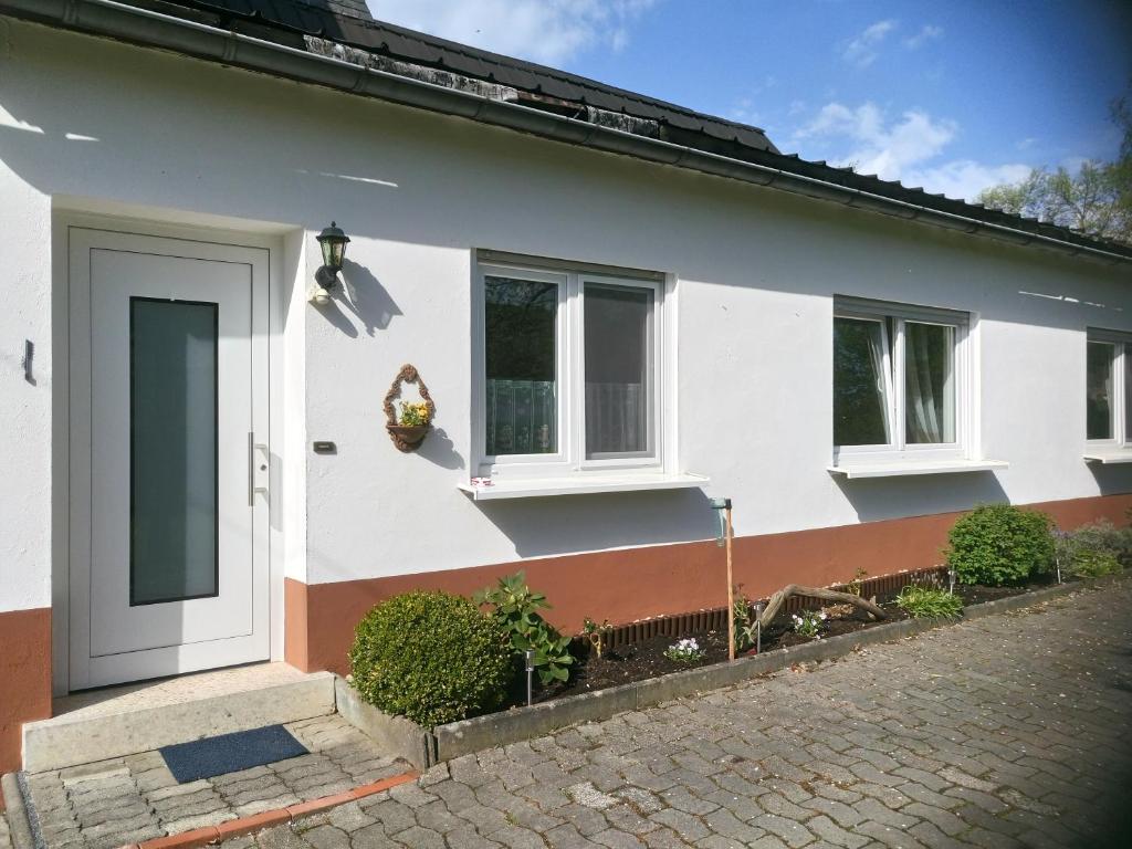a white house with a door and two windows at Ochmanns Ferienwohnung in Meschede