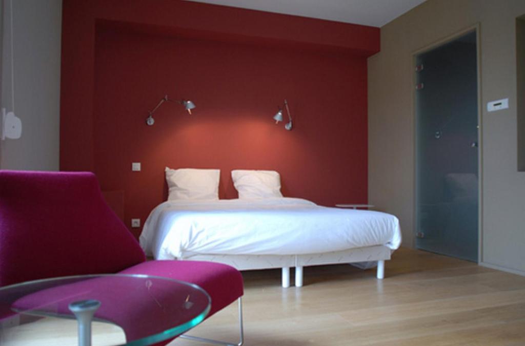 een slaapkamer met een wit bed en een rode muur bij Temporesidence Cathedrale in Bayonne