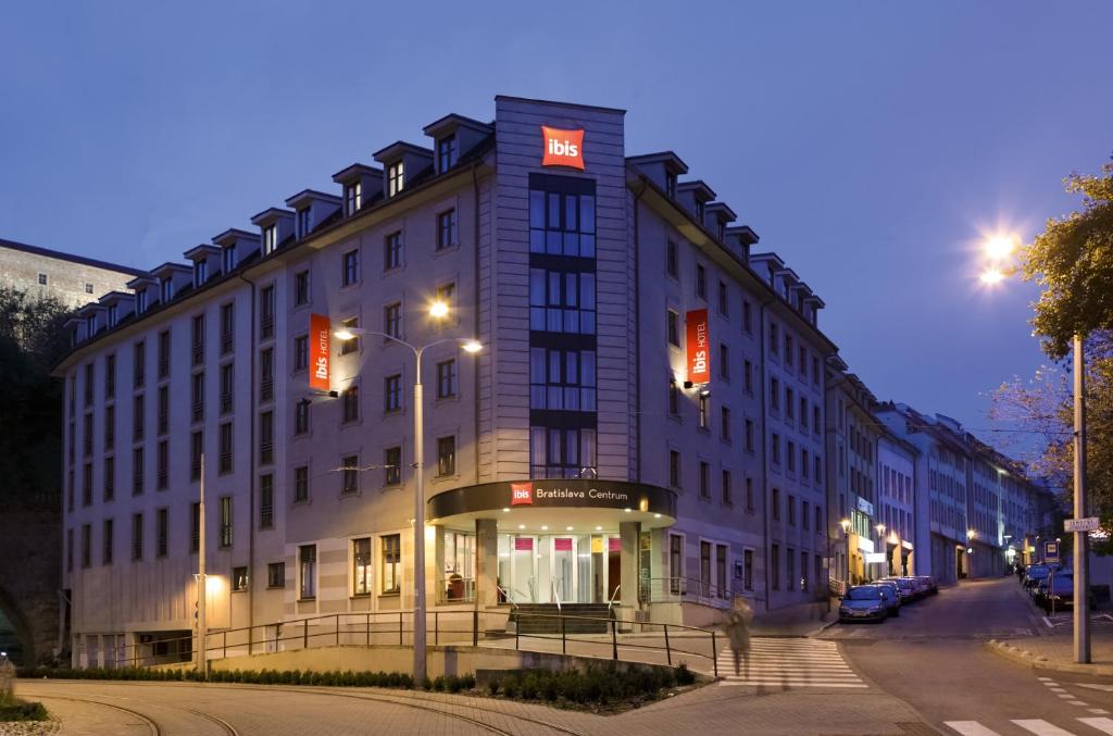 a large building with a sign on it on a street at Ibis Bratislava Centrum in Bratislava