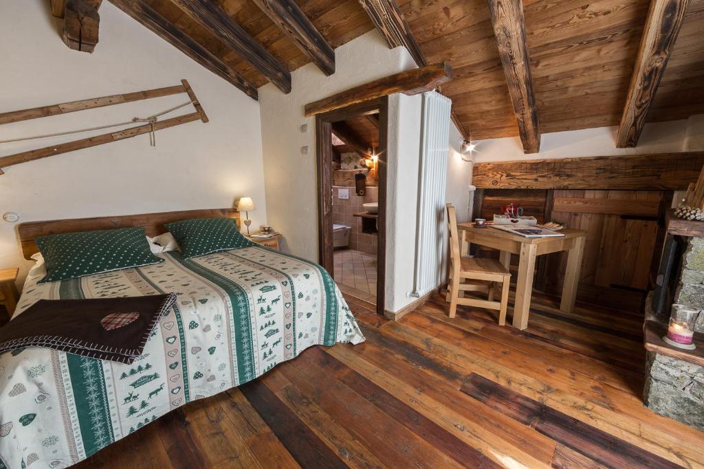 a bedroom with a bed and a desk in a room at La Maison D'Antan in Bionaz