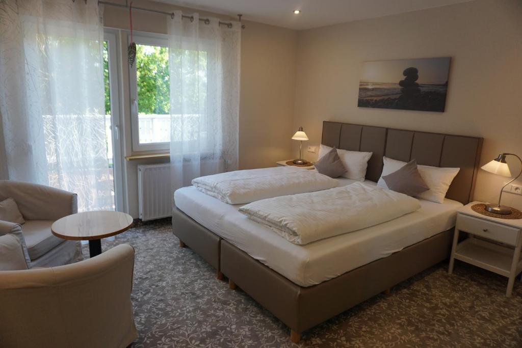 a bedroom with a bed and a chair and a window at Mansion in Bad Arolsen