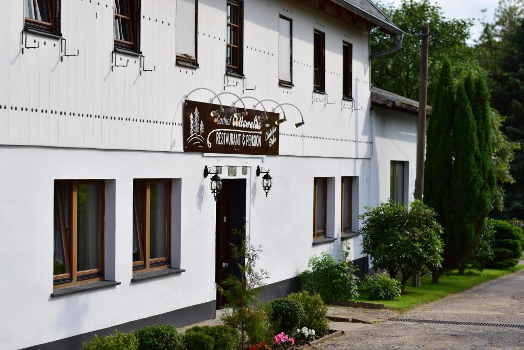 ein weißes Gebäude mit einem Schild auf der Vorderseite in der Unterkunft Gasthof Uttewalde in Uttewalde