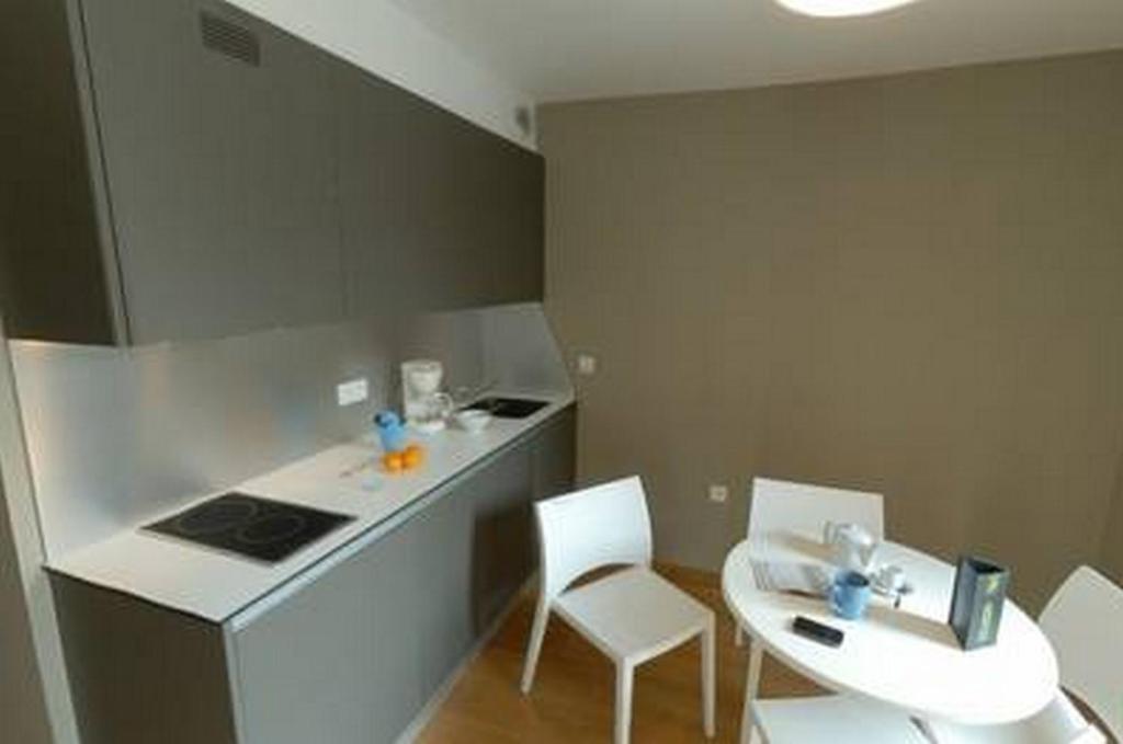 a kitchen with two white chairs and a table and a counter at Temporesidence Cathedrale in Bayonne