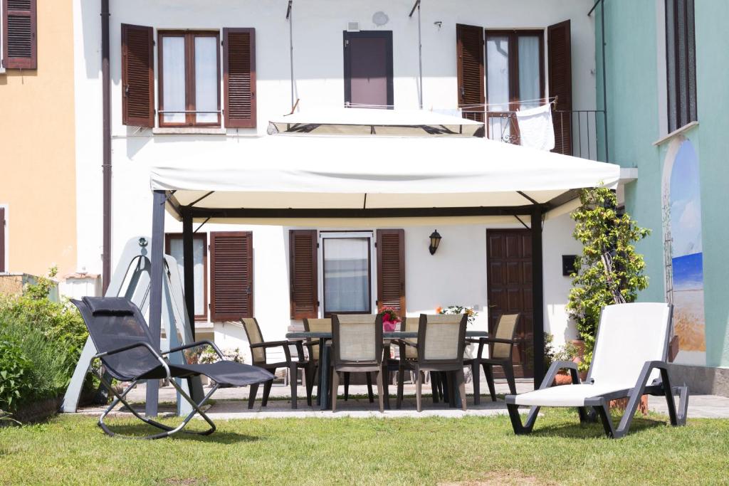 a patio with chairs and a table and an umbrella at La Casa di Cristina in Arona