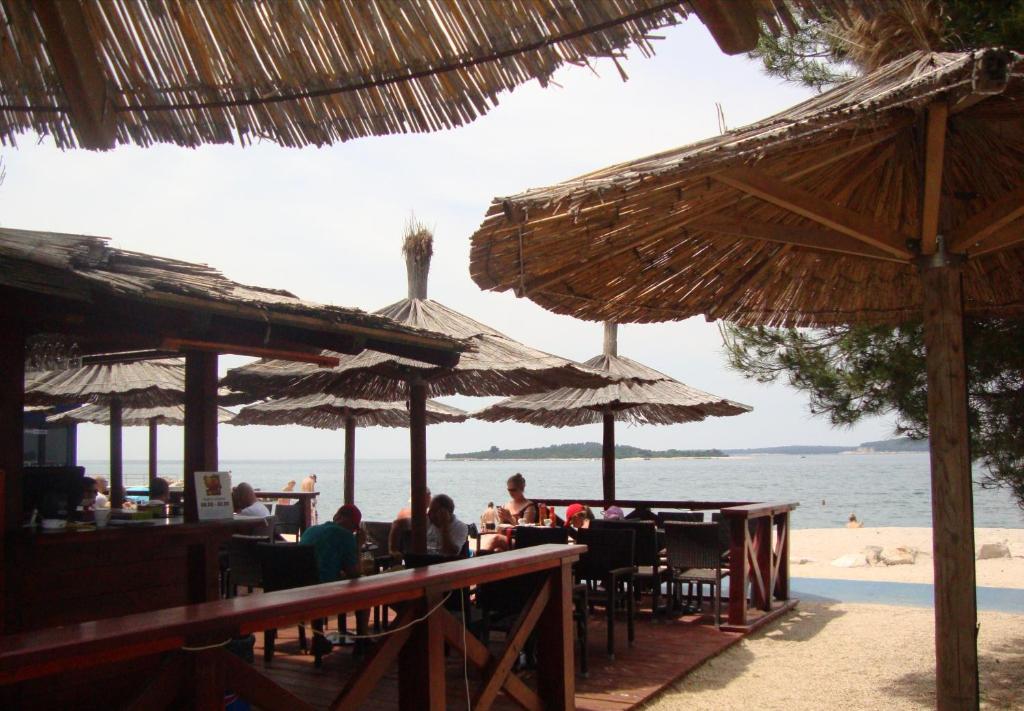 un gruppo di persone sedute in spiaggia con ombrelloni di Apartment Mirta a Pola (Pula)
