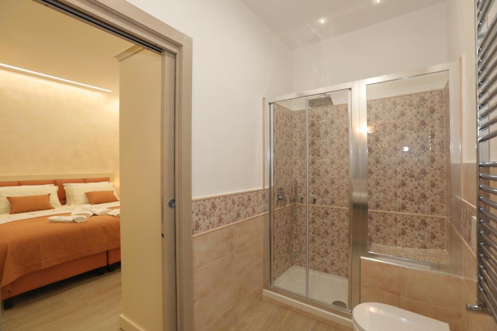 sypialnia z łóżkiem i przeszkloną kabiną prysznicową w obiekcie Relais Ohana - De Vivo Realty w mieście Arola