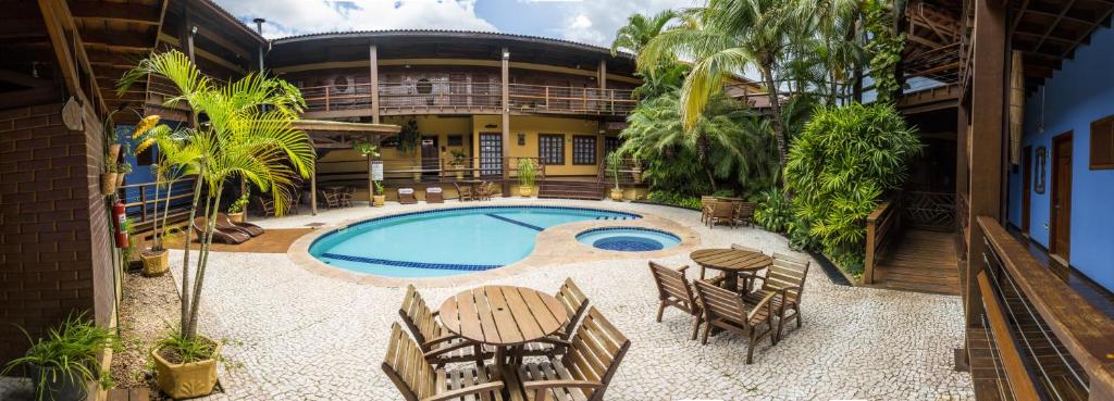 eine Außenterrasse mit einem Pool sowie Tischen und Stühlen in der Unterkunft Hotel Pirá Miúna in Bonito