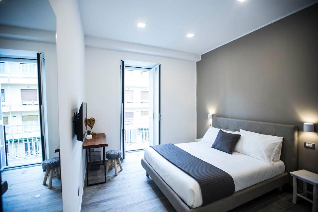 Un dormitorio con una cama y una ventana grande. en GB Central Station Napoli, en Nápoles