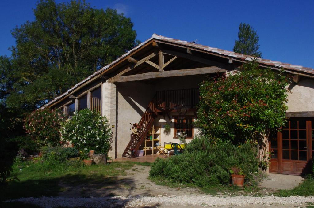 una pequeña casa con un porche y un árbol en Le Grangé, en Giscaro