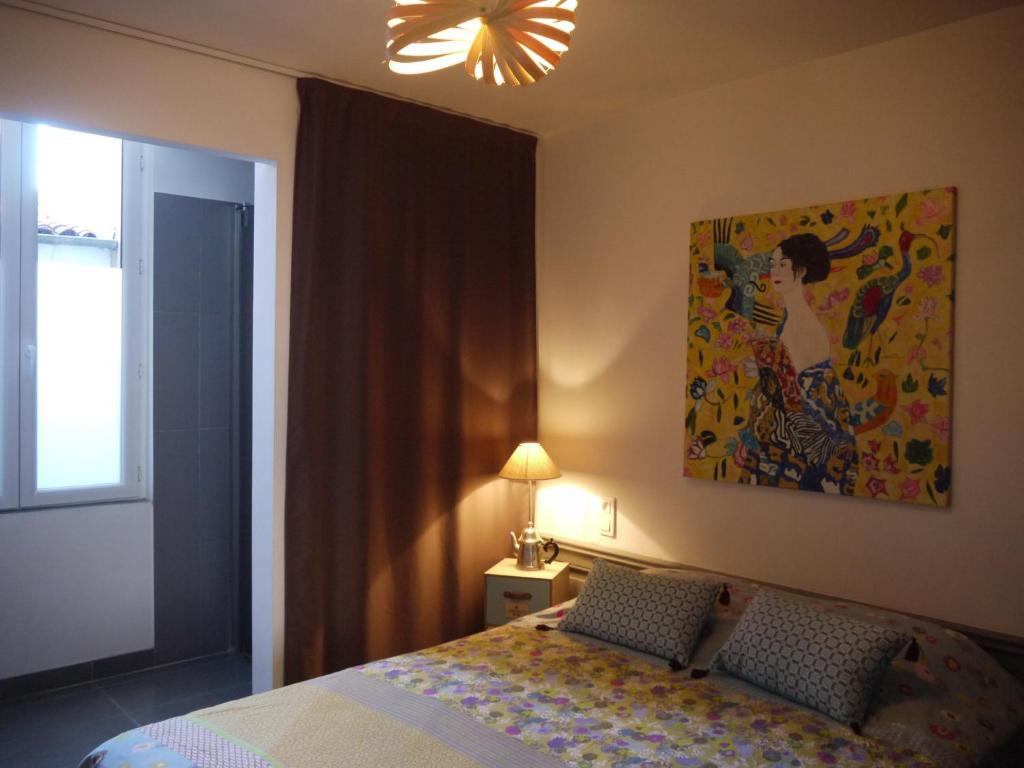 - une chambre avec un lit et une peinture murale dans l'établissement Albert 1er, à La Rochelle