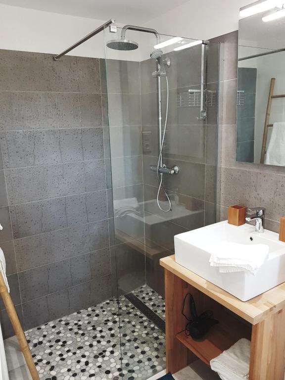 a bathroom with a glass shower and a sink at Villa Manoe in Draguignan