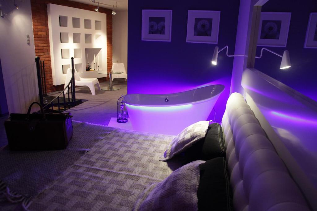 1 dormitorio con bañera en una habitación púrpura en Loft Suite en Lodz