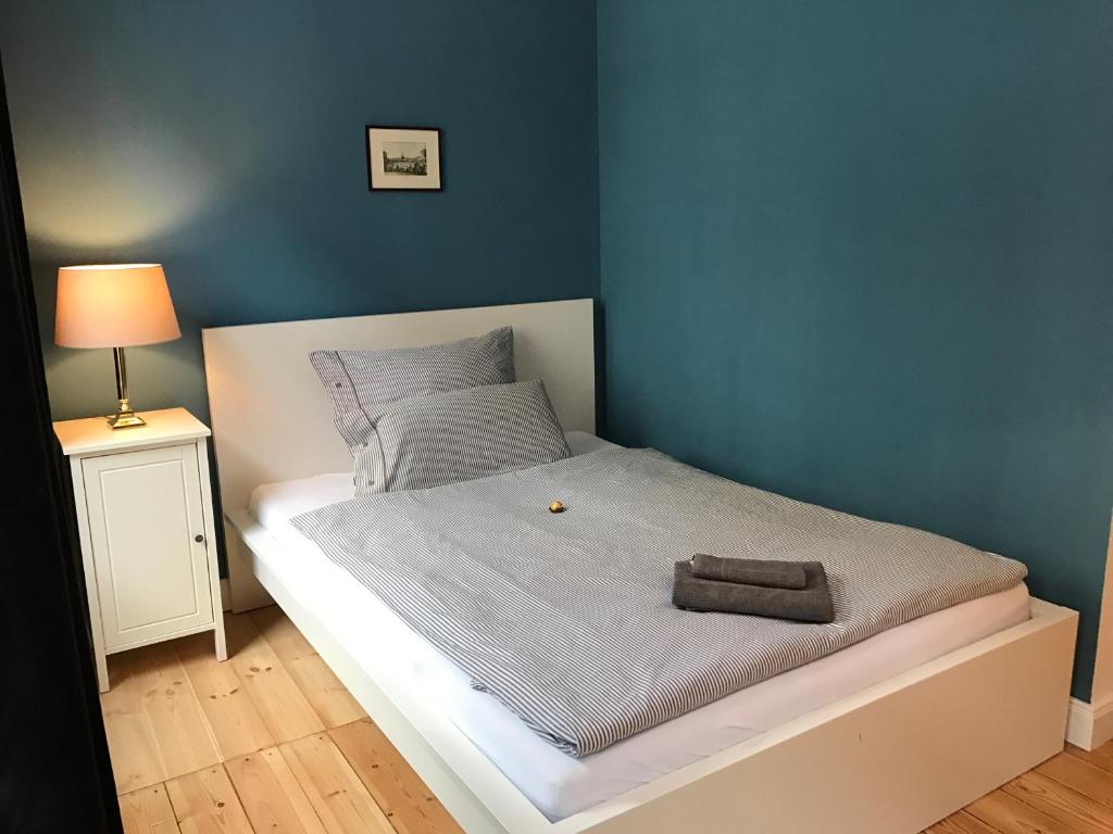Schlafzimmer mit einem Bett mit blauer Wand in der Unterkunft Nord Apartment in Kiel