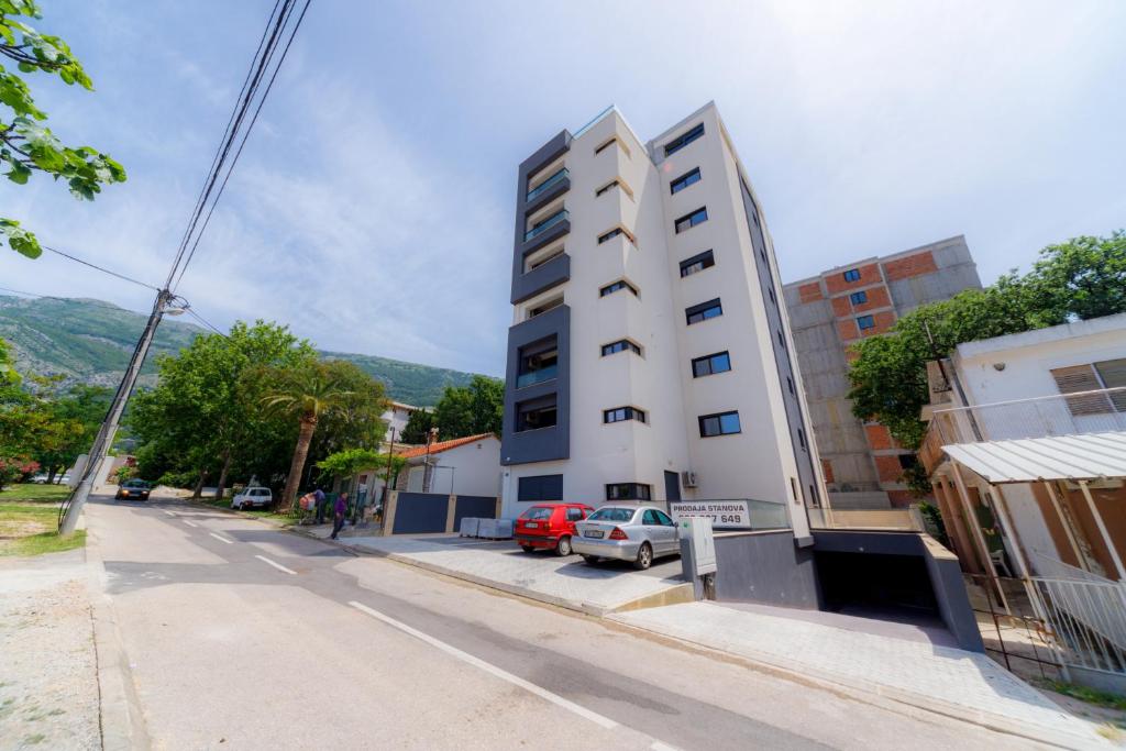 a tall white building on the side of a street at N Apartments in Sutomore