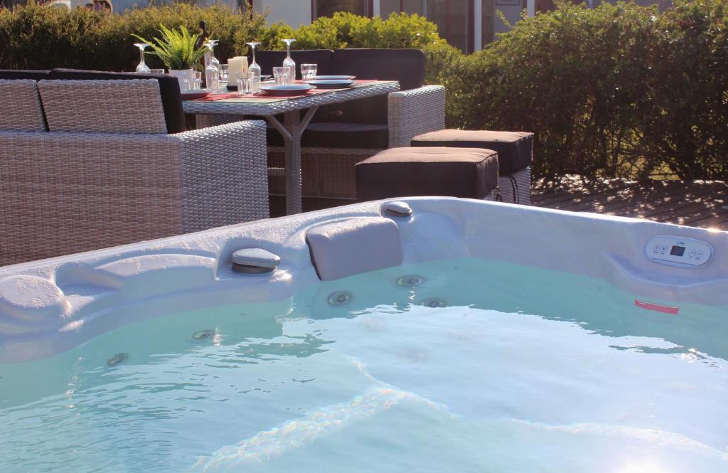 a jacuzzi tub in a yard with a table at Le Prat - Santec in Santec